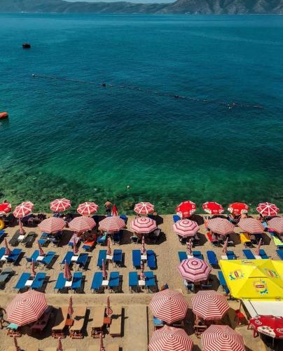 une vue aérienne d'une plage avec des chaises et des parasols dans l'établissement Magic View, à Vlorë