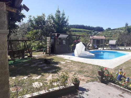 un patio trasero con piscina y una casa en Finca con dos casas rurales, en Randufe
