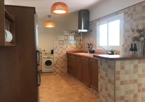 a kitchen with a sink and a washing machine at Casa Rural Relax & Nature in Prado del Rey