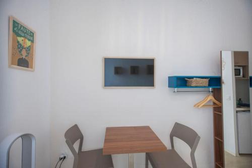 une cuisine avec une table et deux chaises et une télévision dans l'établissement SENAC - Havre citadin, La Canebière, à Marseille