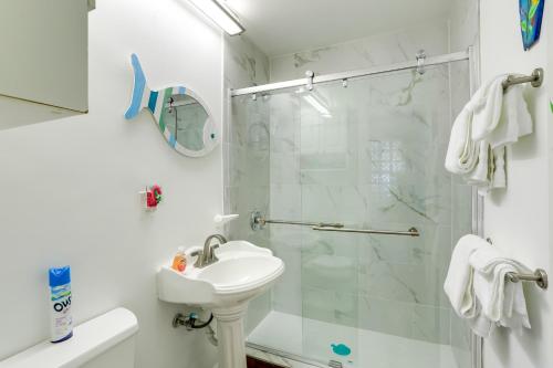 a white bathroom with a shower and a sink at Colorful Gulfport Home Walk to the Art District! in St Petersburg