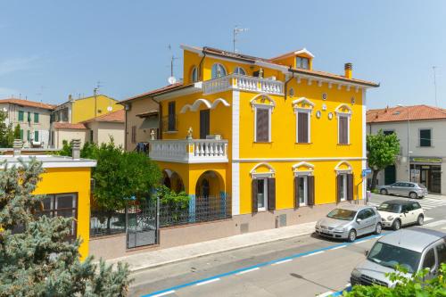 a yellow building with cars parked in front of it at La Casa di Bianca in Follonica