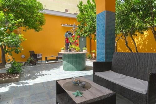 a patio with chairs and tables and a yellow wall at La Casa di Bianca in Follonica