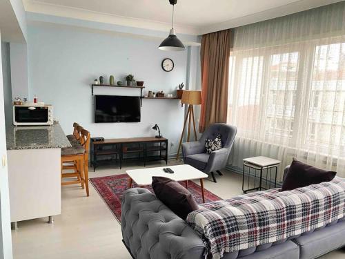 uma sala de estar com um sofá e uma mesa em VİP ŞİŞLİ SQUARE CENTRAL HOUSE em Istambul