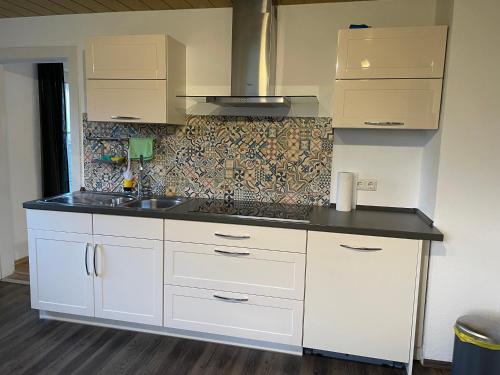 a kitchen with white cabinets and a sink at #7 Doppelzimmer mit Gemeinschaftsbad in Memmingen
