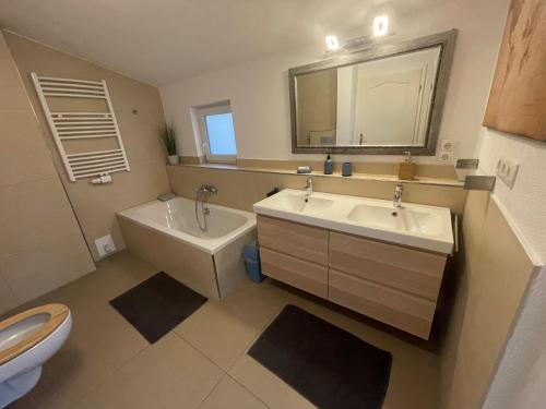 ein Badezimmer mit einem Waschbecken, einem WC und einem Spiegel in der Unterkunft #7 Doppelzimmer mit Gemeinschaftsbad in Memmingen