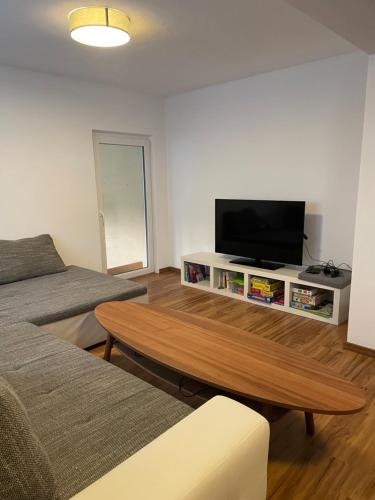 a living room with a tv and a coffee table at #7 Doppelzimmer mit Gemeinschaftsbad in Memmingen