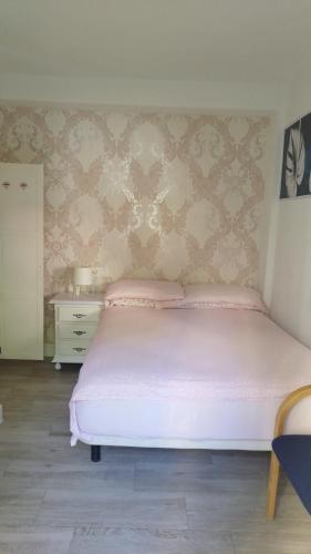 a bedroom with a white bed and a dresser at Habitación independiente céntrica in Fuengirola