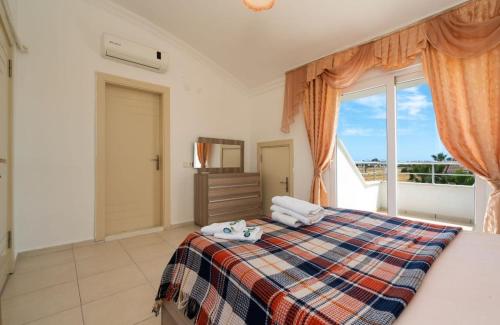 een slaapkamer met een bed en een groot raam bij Dazzling Villa with Private Pool in Antalya in Belek