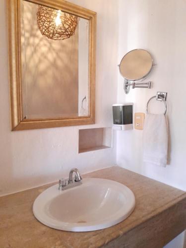 a bathroom with a white sink and a mirror at Xtabentun Hostal in Cancún