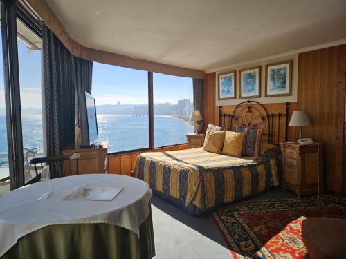 Habitación de hotel con 2 camas y ventana grande. en Hotel Restaurant CapDucal, en Viña del Mar