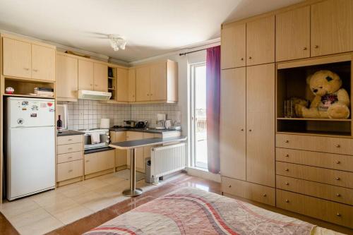 a kitchen with wooden cabinets and a white refrigerator at Loft condo next to metro station. Amazing view! in Athens