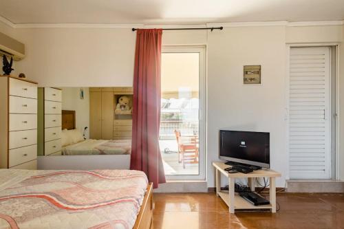 a bedroom with a bed and a television on a table at Loft condo next to metro station. Amazing view! in Athens