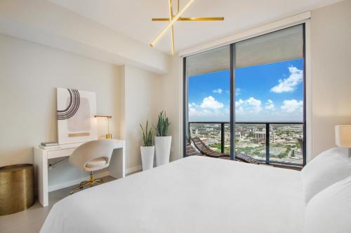 a bedroom with a bed and a desk and a large window at Lunabase Heavenly View in Miami