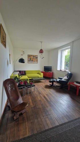 een woonkamer met een gele bank en stoelen bij Chez Mary et Stef in Verdun-sur-Meuse