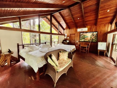 Cirandeira Amazon World EcoResort في Manacapuru: غرفة نوم بسريرين في غرفة بها نوافذ