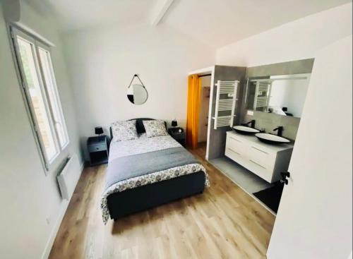 une chambre avec un lit et une salle de bain avec un lavabo dans l'établissement Le Repère de B&C, à Cenon