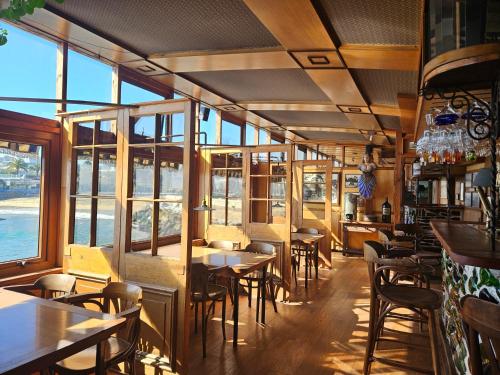 un restaurante con mesas, sillas y ventanas en Hotel Restaurant CapDucal, en Viña del Mar