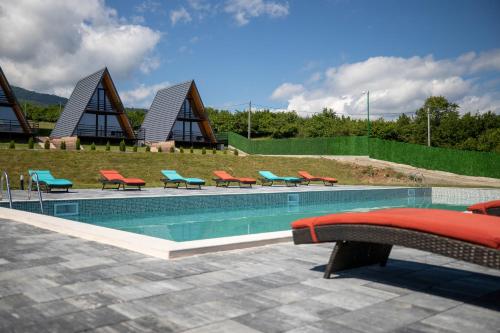 una piscina con mesas y sillas rojas y azules en TITA HOMES, en Telavi