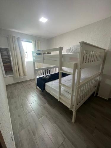 two bunk beds in a room with a wooden floor at Meu Loft Barra Nova 4 in Saquarema