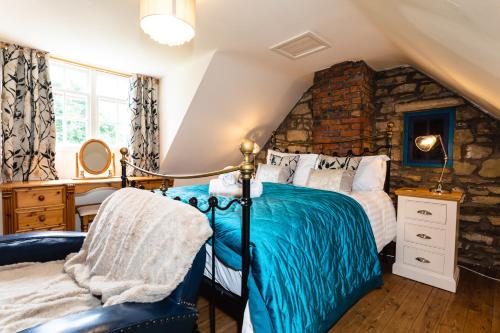a bedroom with a bed and a stone wall at The Poachers Pocket in Whittingham