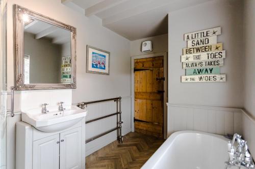 y baño con bañera, lavabo y espejo. en The Poachers Pocket en Whittingham