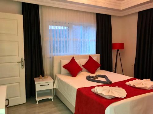 um quarto com 2 camas com almofadas vermelhas e uma janela em Tyana Home-1 em Kas