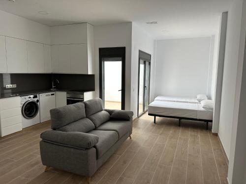 a living room with a couch and a bed at Kaypa Apartaments in Pineda de Mar