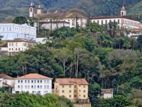 un grupo de edificios en una colina con árboles en Casa da tranquilidade en Ouro Preto