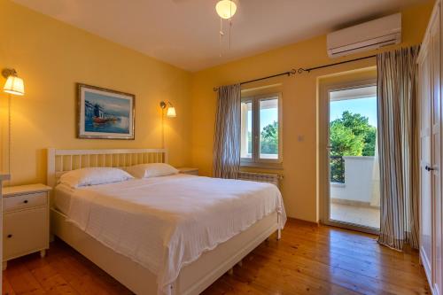 RakaljにあるKapetanova Villaのベッドと大きな窓のある寝室