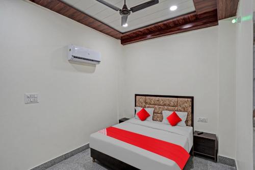 um quarto com uma cama com almofadas vermelhas em Flagship Shree Shyam Residency em Nova Deli