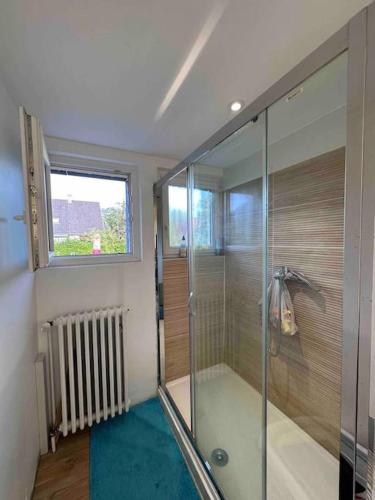 une salle de bain avec une douche en verre avec une fenêtre dans l'établissement Maison familiale proche Strasbourg, à Illkirch-Graffenstaden