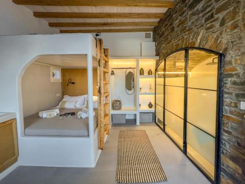 a small room with a bed and a brick wall at KL , Cozy Suite II in Kithnos