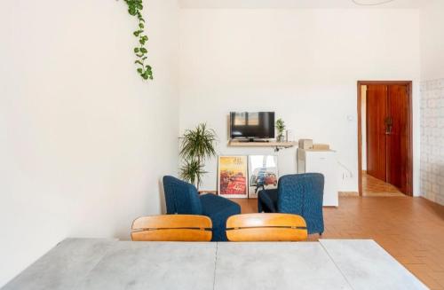 sala de estar con 2 sillas azules y mesa en Airbnb Porretta, en Porretta Terme