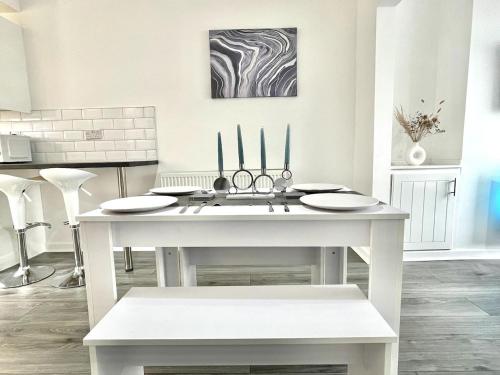 uma cozinha com uma mesa branca com pratos em Modern House Liverpool em Liverpool