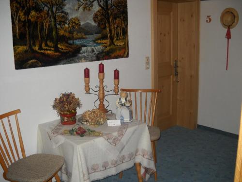 a dining room table with red candles and flowers on it at Gästehaus Maria in Kartitsch