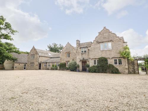 an old stone house with a large driveway at Home Farm 16 in Witney