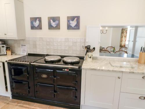 a kitchen with a stove top oven in a kitchen at Home Farm 16 in Witney