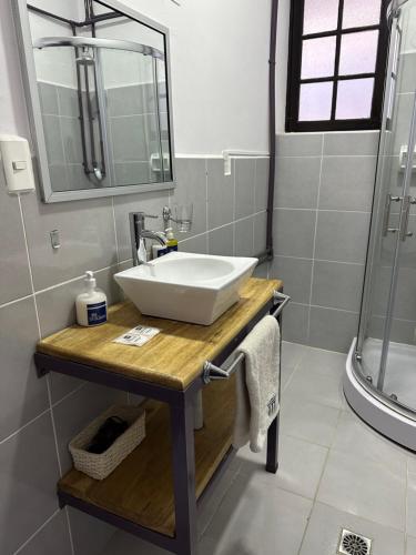 La salle de bains est pourvue d'un lavabo blanc et d'une douche. dans l'établissement El Museo Hotel Boutique, à La Paz