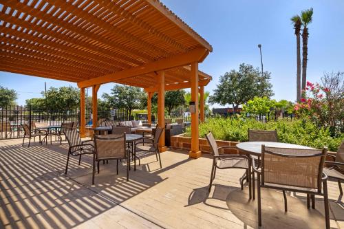 a wooden deck with tables and chairs and a pavilion at Best Western Plus Downtown North in San Antonio
