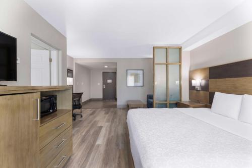 a hotel room with a bed and a flat screen tv at Best Western Plus Downtown North in San Antonio
