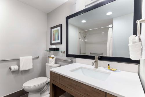 a bathroom with a sink and a toilet and a mirror at Best Western Plus Downtown North in San Antonio