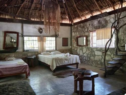 a bedroom with two beds in a stone building at Ecolodge Uh May in Francisco Uh May