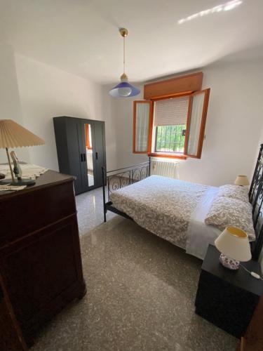 een slaapkamer met een bed, een dressoir en een raam bij Apartments Isi & Lory in Casalecchio di Reno