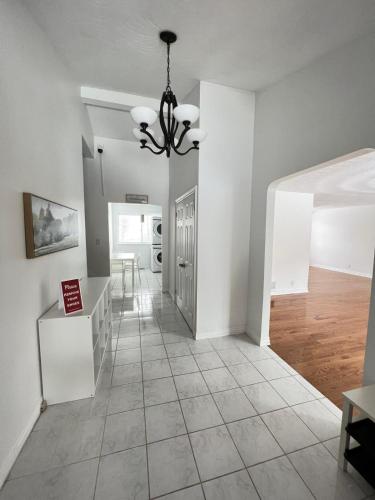 a living room with white walls and a chandelier at Letitia Heights !C Quiet and Modern Private Bedroom with Shared Bathroom in Barrie