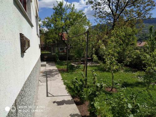 um jardim ao lado de uma casa com árvores e plantas em Guesthouse Vratnik em Saraievo