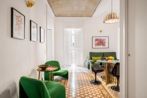 a living room with green chairs and a table at 124 Maqueda Apartments in Palermo