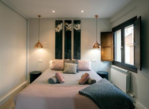 a bedroom with a large bed with pillows on it at El Arco San Esteban by Unique Rooms in Burgos