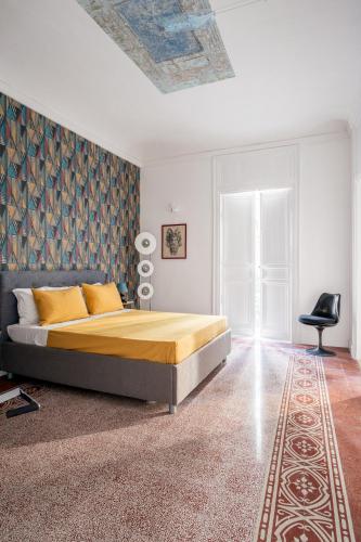 a bedroom with a bed and a chair in it at 124 Maqueda Apartments in Palermo