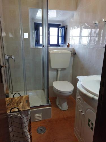 a bathroom with a shower and a toilet and a sink at Casa da Serra in Nazaré